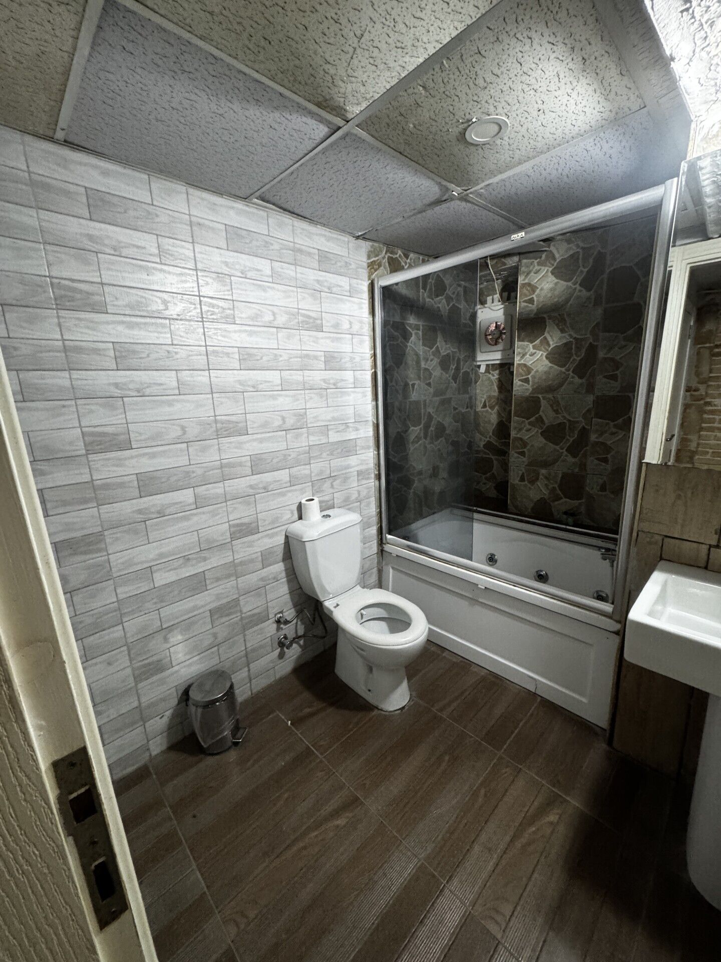 Une salle de bain avec des toilettes, une douche et un lavabo.