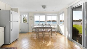 A modern kitchen with a dining area overlooking a lake. - Cozy Lakefront 2bd Duplex on Long Lake (Traverse City)