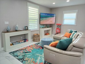 A living room with a sofa, a TV, a coffee table, and a patterned rug.