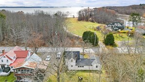 Un quartier résidentiel avec des maisons, une route et une étendue d’eau en arrière-plan.