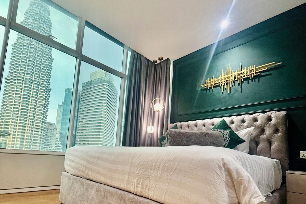 Un dormitorio moderno con una cama grande, vistas a la ciudad y un elemento decorativo en la pared.