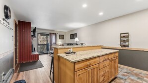 A compact kitchen with wooden cabinets, a granite countertop, and a small island. - Mountain Charmer | Steps to Main St & Trails (Frisco)