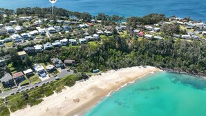 An aerial view of a coastal residential area with houses, a beach, and a forested area. - Strandhus in Mollymoook (Mollymook Beach)