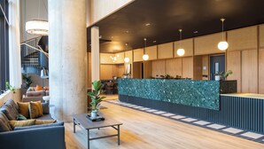 A modern lobby with a reception desk, seating area, and staircase. - Enclave Croydon - Campus Accommodation (Croydon)