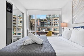 Una camera d'albergo con un letto grande, una scrivania e vista sulla città.