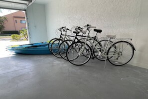 Un garage contenant des vélos et un kayak.