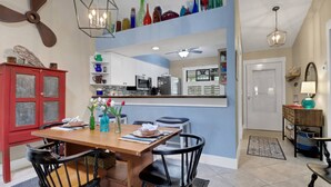 A dining area with a wooden table, black chairs, and a red cabinet. - 11961 Caraway Ln #87 (Fort Myers)