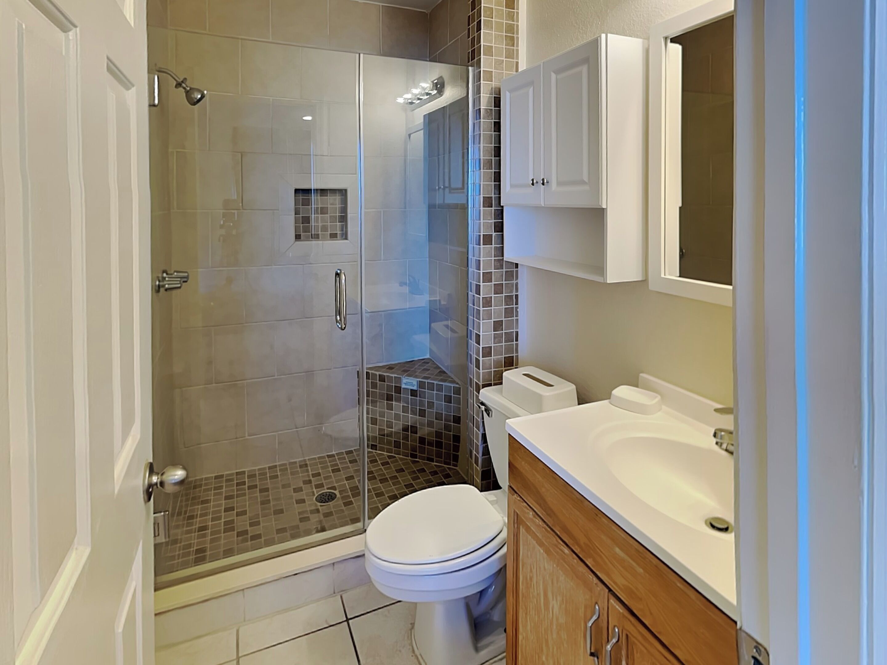 Une salle de bain moderne avec une douche à parois de verre, des toilettes, un lavabo et un meuble de rangement.