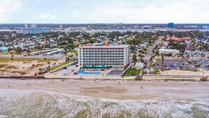 A hotel with a central courtyard, multiple floors, and a beach view. - Harbour Beach Resort 103 (Daytona Beach)