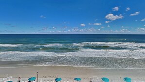 A beach with a clear sky, waves, and umbrellas. - Harbour Beach Resort 603 (Daytona Beach)