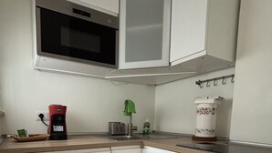 A compact kitchen with white cabinets, a microwave, a coffee maker, and a small sink. - Civic8-Navigli-Iulm (Milano)