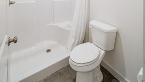 A bathroom with a shower, toilet, and a bathtub. - Affordable Lodge w/Covered, Lighted, Pull Through Parking. Grills and Outdoor TV (Grove)
