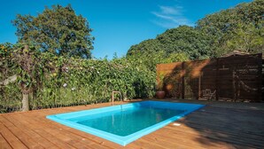 A rectangular swimming pool with a wooden deck surrounding it. - Elegant and Complete Chalets in Imbituba - REL (Imbituba)