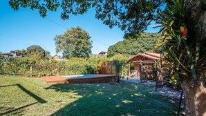 A backyard with a wooden deck, a small pool, and a wooden structure. - Elegant and Complete Chalets in Imbituba - REL (Imbituba)