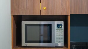 A kitchen with a microwave, a refrigerator, and a cabinet with a potted plant. - Studio in the heart of Morelia! (Morelia)