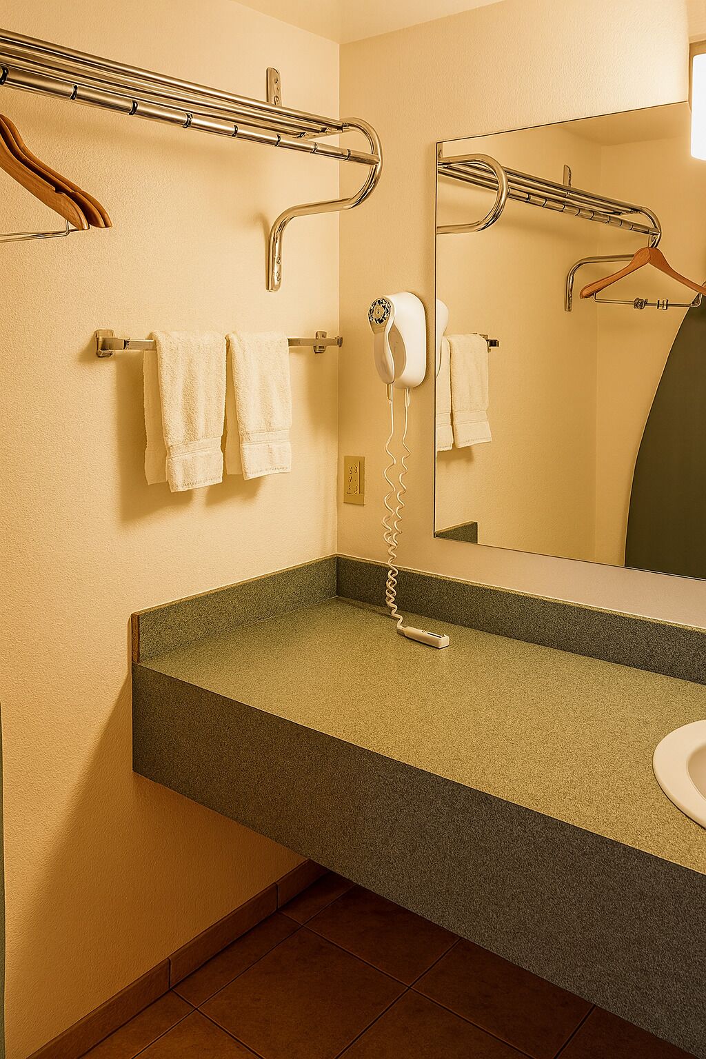 Casa de banho com lavatório, porta-toalhas e secador de cabelo.