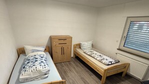 A small, compact room with a single bed, a small desk, and a window with blinds. - Friendly accommodation with parking in a central location (Dieburg)