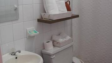 Een douche, handdoeken, zeep, toiletpapier