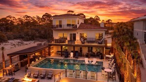 A two-story house with a swimming pool, outdoor seating, and a view of the beach at sunset. - Luxury Waterfront Villa w/ Pool, Hot Tub, Dock & Game Room - Sleeps 28 (Pensacola)