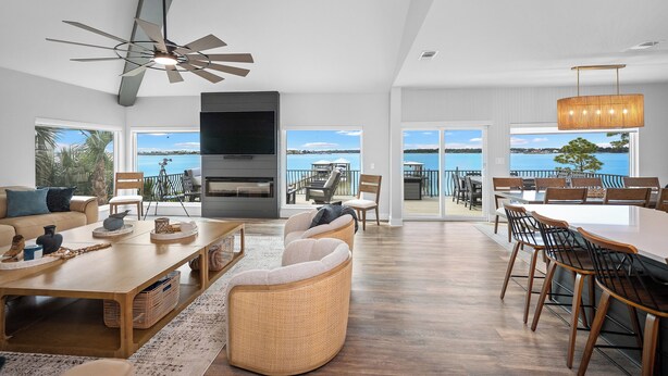 A spacious living area with a fireplace, seating, and large windows offering a view of the outdoors. - Luxury Waterfront Villa w/ Pool, Hot Tub, Dock & Game Room - Sleeps 28 (Pensacola)
