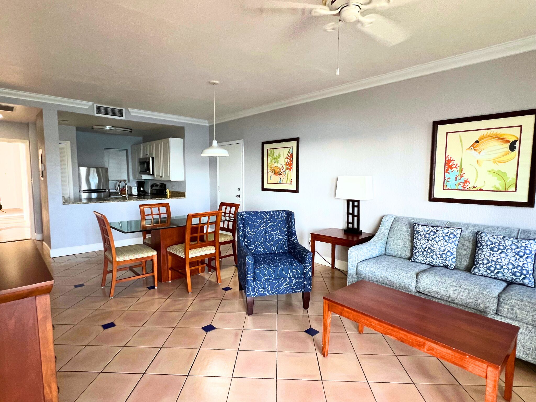 A living room with a sofa, a coffee table, and a dining area with chairs and a table.