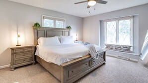 A bedroom with a bed, nightstands, a ceiling fan, and a window. - Nancy`s Ranch + hot tub (Derby)