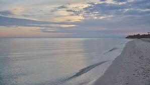 A beach with a calm sea and a clear sky. - KatNap Sisal : Solar-powered Beachfront Retreat (Sisal)