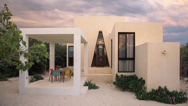 A modern house with a covered patio, a large window, and a small garden. - KatNap Sisal : Solar-powered Beachfront Retreat (Sisal)