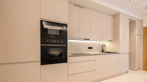 Una cucina moderna con mobili bianchi, forno integrato e un piano di lavoro elegante.