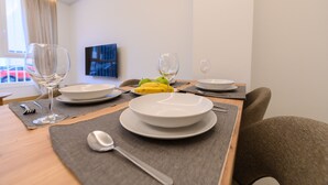 Una tavola imbandita con piatti, posate e un bicchiere di vino bianco.