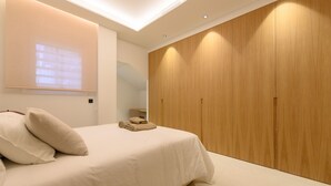 Una camera da letto con un letto, un armadio in legno e una lampada a soffitto.