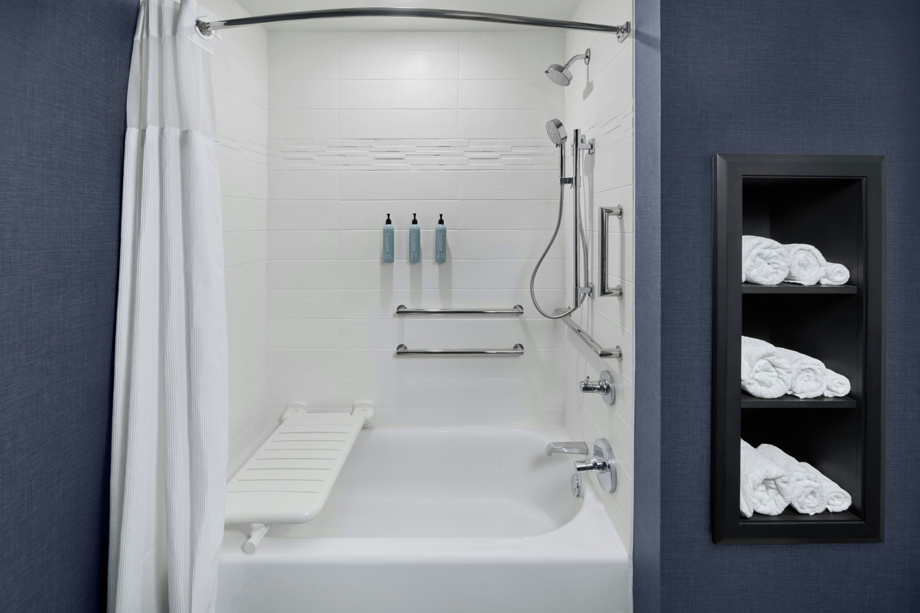 Une salle de bain moderne équipée d’une baignoire, d’une douche et d’un porte-serviettes.