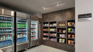 A grocery store interior with refrigerated beverage dispensers, snack shelves, and a sign reading "the market". - Residence Inn By Marriott Traverse City (Traverse City)