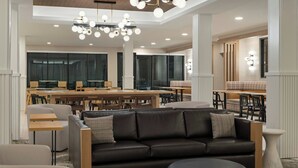 A modern interior with a leather sofa, wooden tables, and a chandelier. - Fairfield By Marriott Inn & Suites Corbin (Corbin)