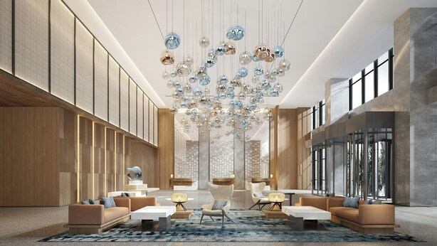 Un hall d’entrée spacieux, doté d’un mobilier moderne, d’un grand lustre et de larges fenêtres laissant entrer la lumière naturelle.