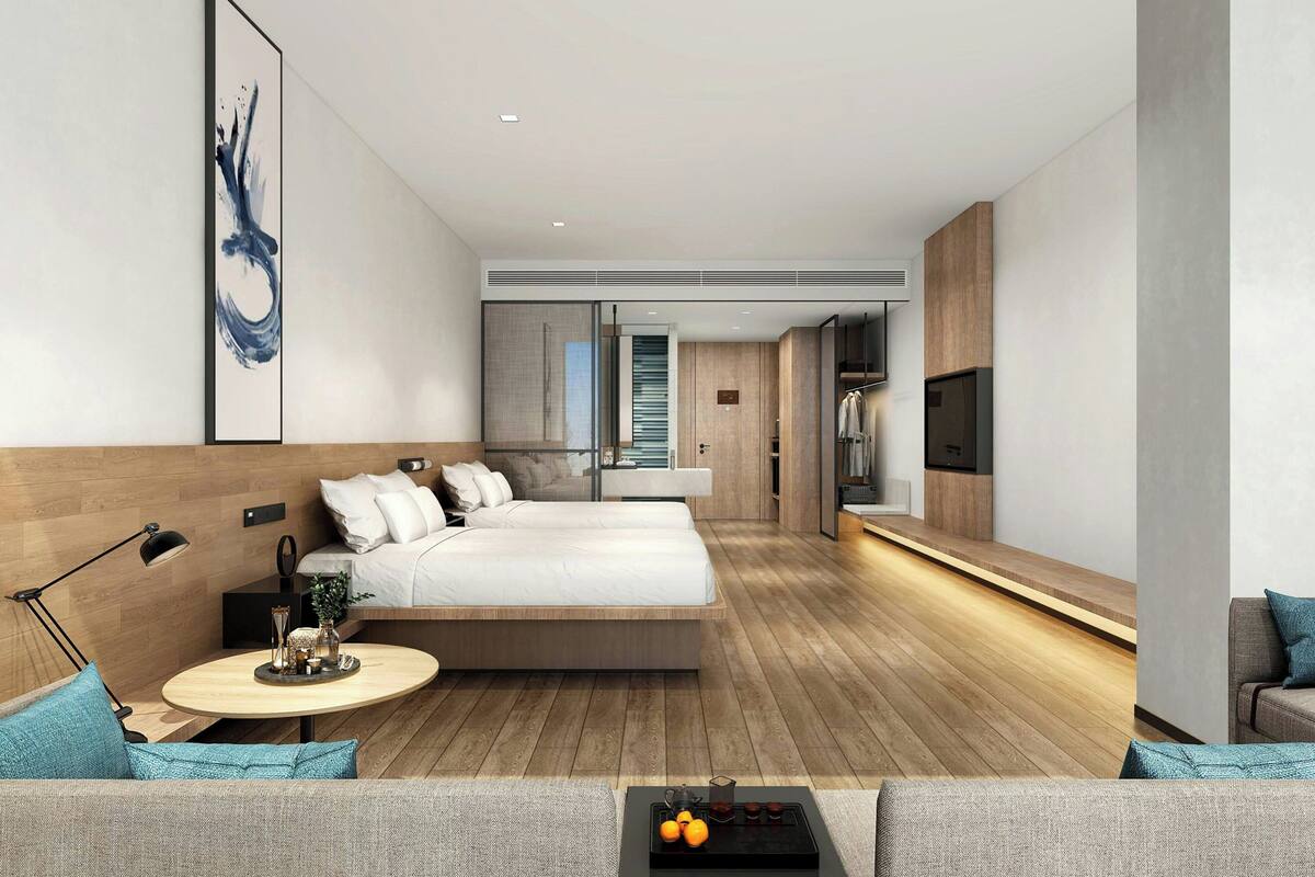 Une chambre d’hôtel moderne avec un grand lit, une table basse ronde et un canapé.