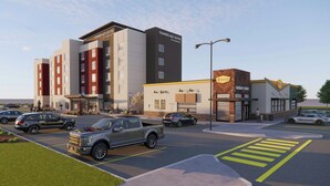 Un hotel con varias suites, un comedor y un estacionamiento con vehículos.