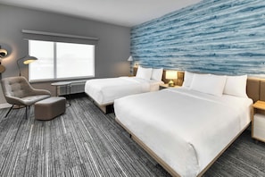 A hotel room with a large bed, a chair, a desk, and a view of the outdoors.