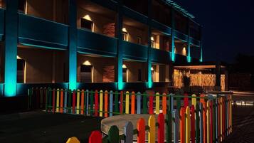 A multi-story hotel with balconies and a colorful fence.