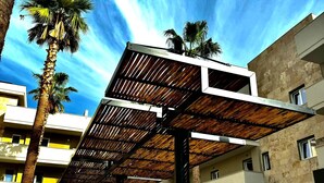 A modern building with a flat roof and a brick-paved courtyard. - Paradisea club and residences (Volla)