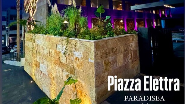A modern building with a stone facade and a rooftop garden. - Paradisea club and residences (Volla)