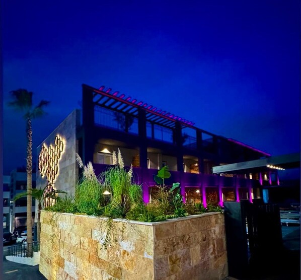A modern building with a stone facade and a rooftop garden. - Paradisea club and residences (Volla)