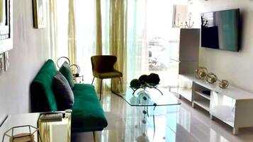 Appartamento Deluxe, balcone, vista città | Area soggiorno | TV LED 55 pollici con canali digitali