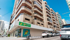 A multi-story building with a green storefront featuring a cartoon character. - Fully Equipped Apartments in Meia Praia, 150m From the sea - Eoos (Itapema)