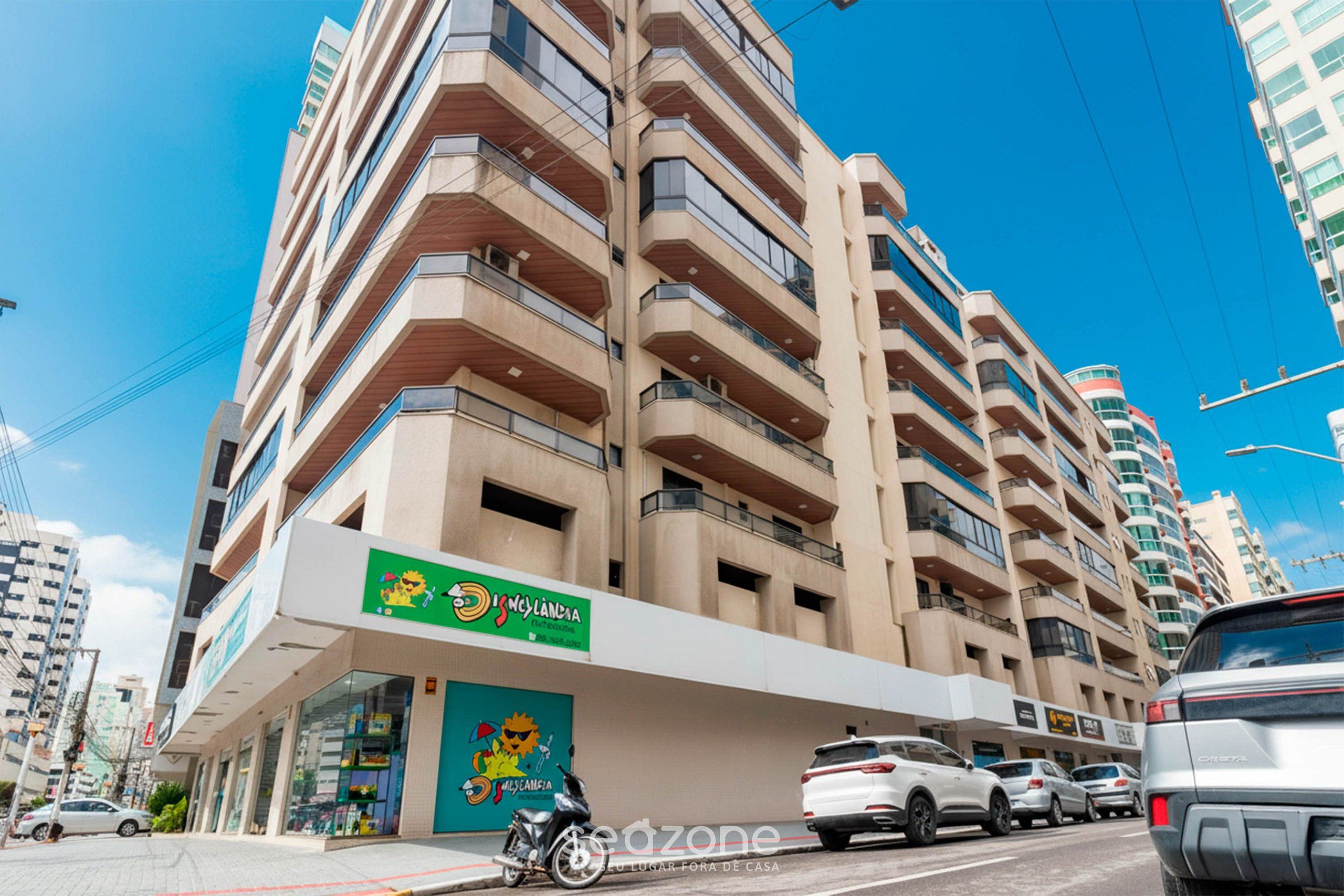 Um edifício com vários andares e fachada verde com um personagem de desenho animado.