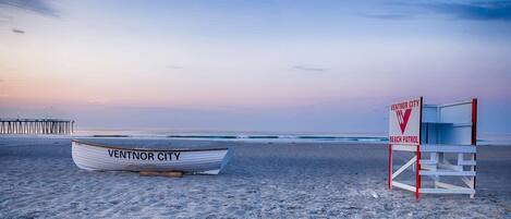 A beach with a lifeguard tower and a boat labeled "VENTNOR CITY" on the sand.
