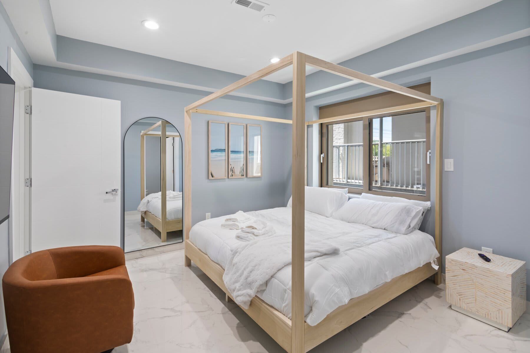 Ein modernes Schlafzimmer mit einem Himmelbett, einem Nachttisch aus Holz und einem Marmorboden.