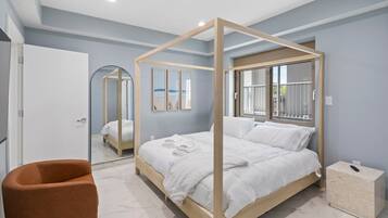 Ein modernes Schlafzimmer mit einem Himmelbett, einem Nachttisch aus Holz und einem Marmorboden.