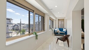 Un salon spacieux avec une grande fenêtre, un canapé bleu et une plante.