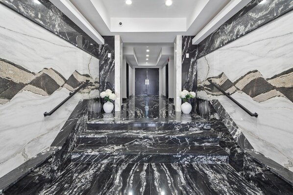 A marble staircase with a modern design, leading to a door at the end. - Ammos Luxury Living- Paros Suite (Ventnor City)